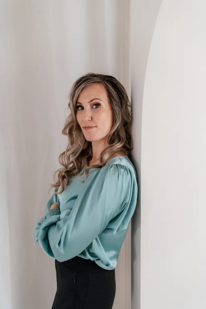 Portret van stemactrice Kirsten van Stenis in een groene blouse tegen witte achtergrond